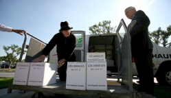 Howard Dillon unloads boxes of signatures as Judge James P. Gray looks on at the Los Angeles County registrar/recorder-county clerk's office in Norwalk. (Photo by Francine Orr)